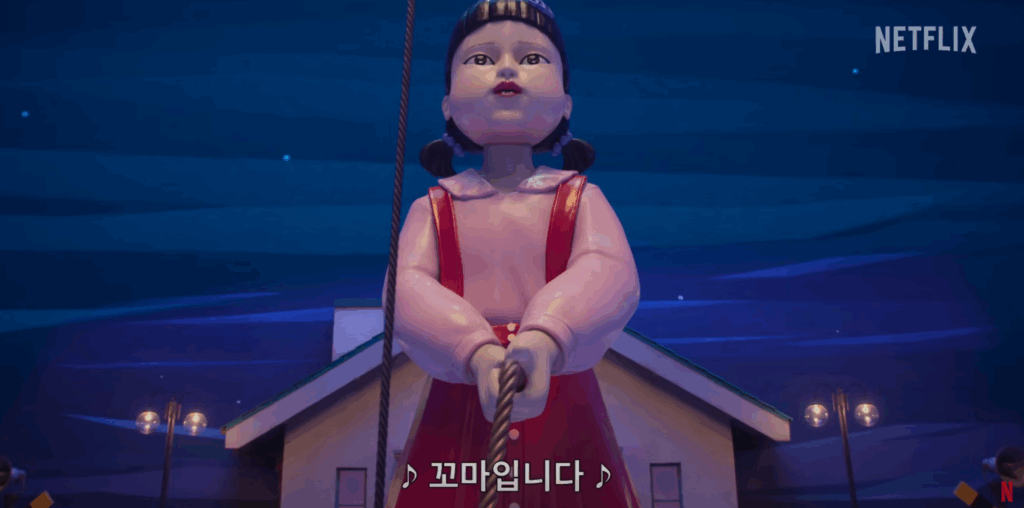 Squid Game Season 3 trailer shows the giant doll, Young-hee, under a blue night sky.