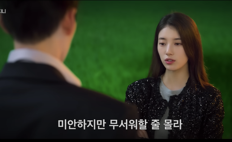Female lead wearing a black jacket talking calmly in a dramatic scene from Genie, Make a Wish