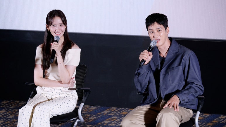 YoonA and Ahn Bo Hyun holding hands during a stage greeting, showcasing chemistry in Pretty Crazy box office comeback