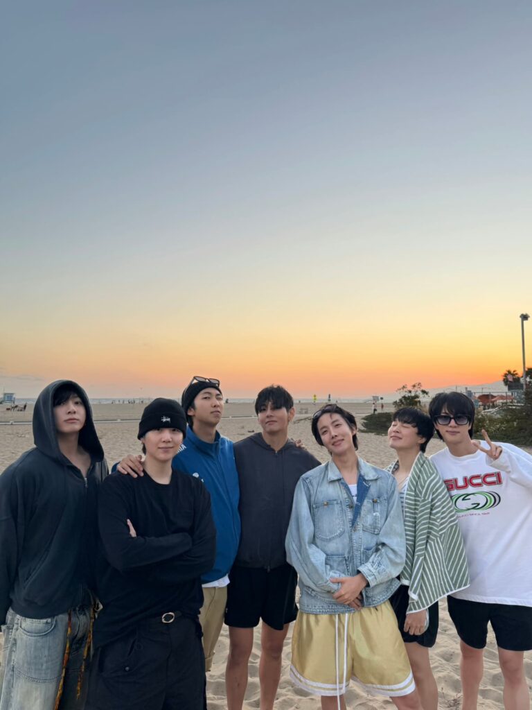 BTS members reunite on a beach at sunset ahead of their full-group comeback in 2026
