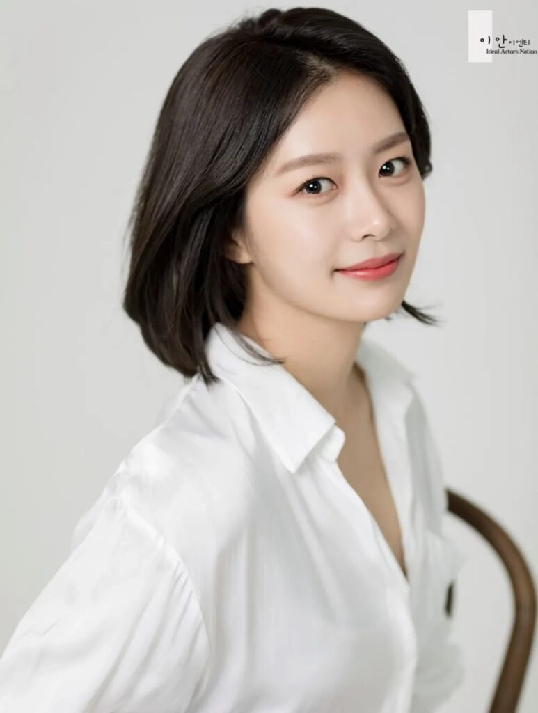 Actress Song Da Eun smiles in a white blouse, gaining attention during the Jimin dating scandal.