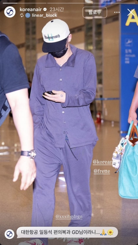 Full-body view of G-Dragon walking through Incheon Airport in exclusive Korean Air first-class loungewear, setting a new fashion trend.