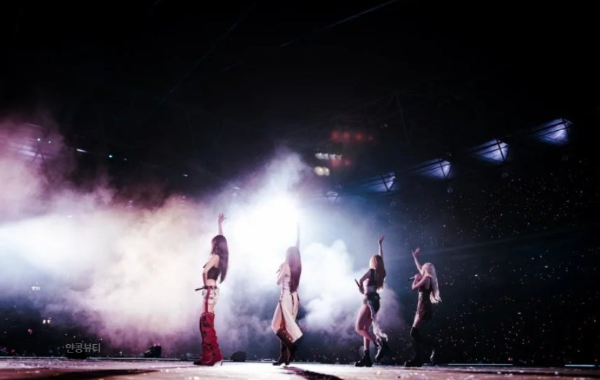 BLACKPINK power pose mid-performance with dramatic lighting on DEADLINE World Tour 2025