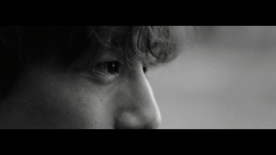 Black and white close-up shot of a man's eyes and face, conveying deep thought and emotion