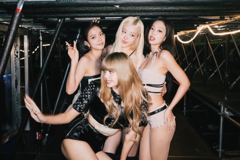 BLACKPINK members hugging on stage, celebrating their unity and energy during YG comeback plans 2025.