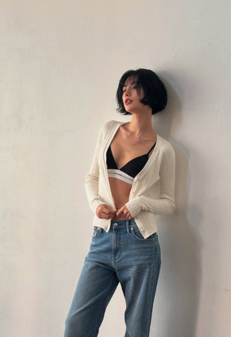 Nana embraces a soft yet powerful mood in a cardigan and jeans, echoing the calm before her bold "Nana Seventh Heaven 16" comeback storm.