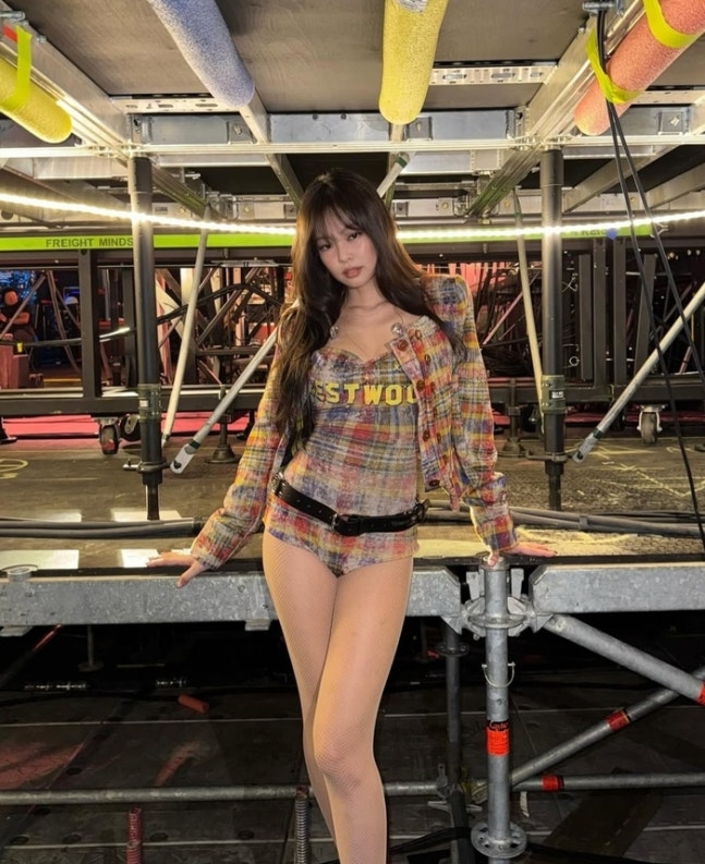 Jennie posing backstage in a Vivienne Westwood plaid bodysuit outfit during her RIAA-certified performance
