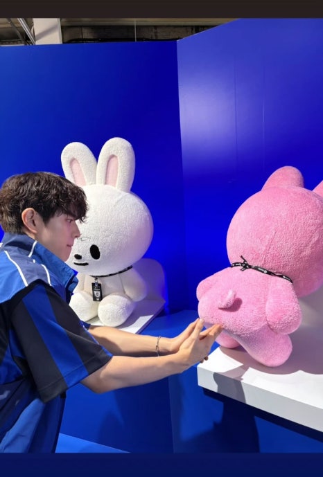 Stray Kids member interacting with character mascot during Billboard 200 record promotions