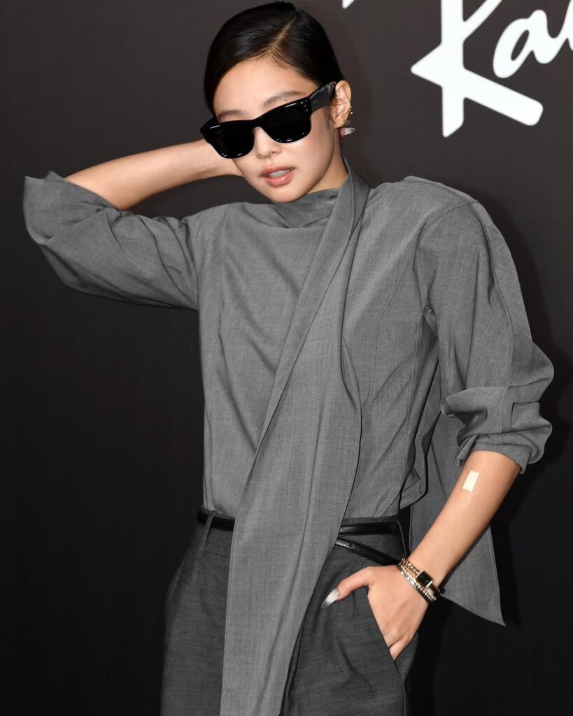 Jennie në një event të Ray-Ban me një veshje elegante gri dhe syze dielli, një soliste e K-pop-it modern — Certifikimet e Jennie RIAA