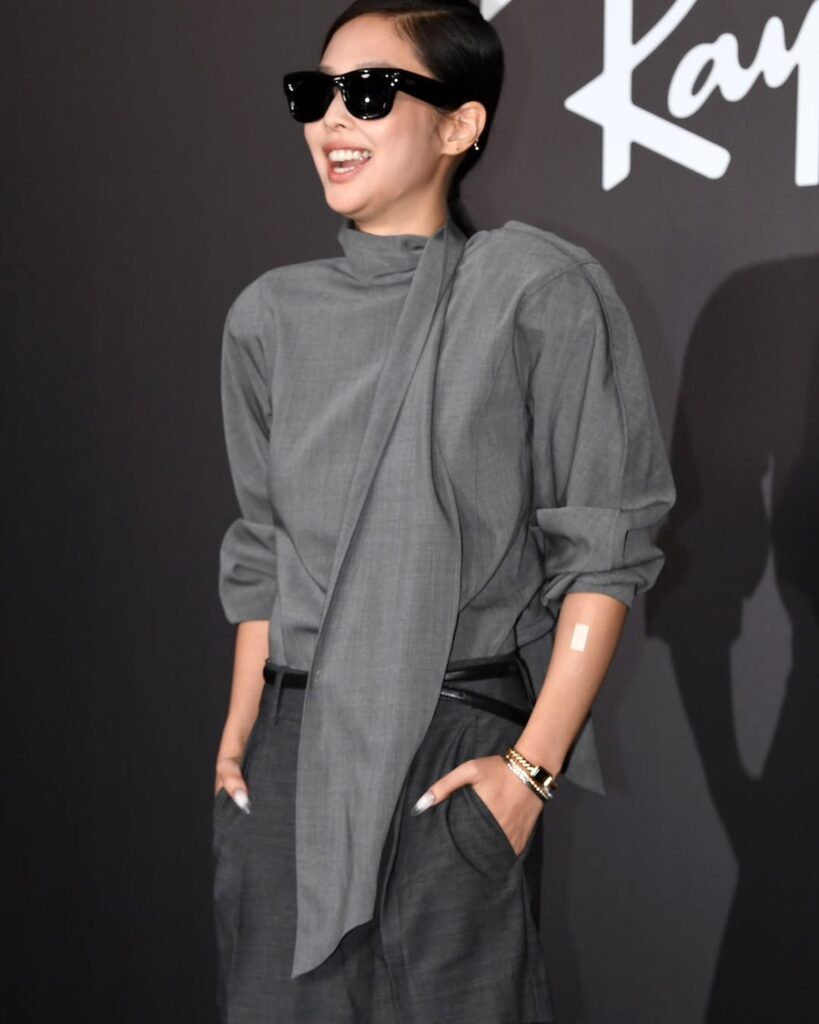 Jennie laughing in gray formal wear at Ray-Ban showcase, radiating star power — Jennie RIAA certifications