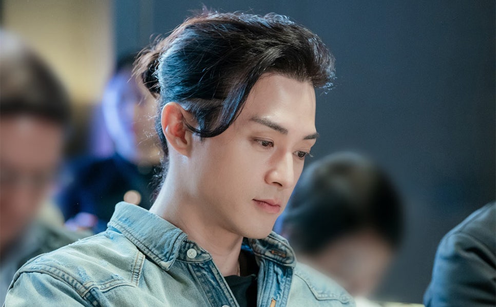 A male actor in a denim jacket deeply engaged in the script of “Nice to Not Meet You.”