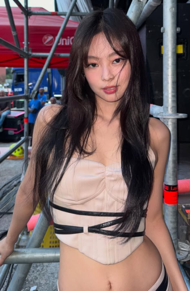 Jennie winking and saluting with joy backstage after her explosive RIAA-certified concert
