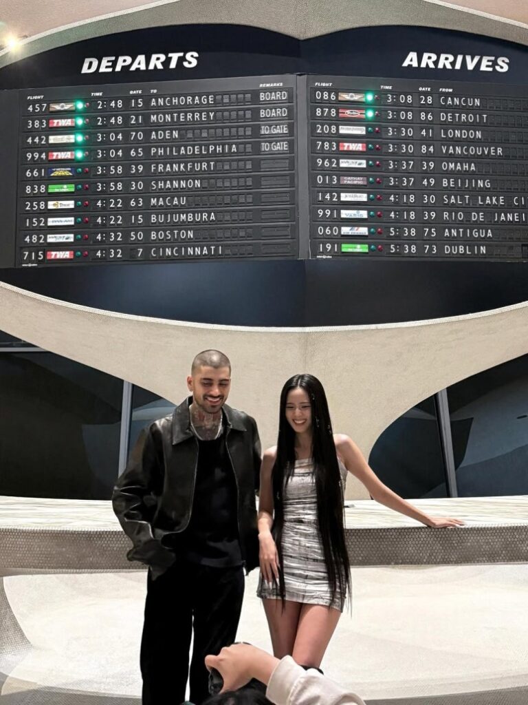 Jisoo and Zayn Malik posing playfully under a Departures sign for Eyes Closed music video shoot