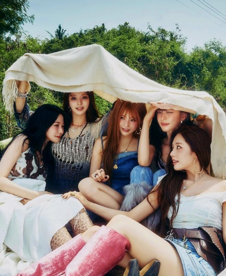Outdoor photo of <strong>fromis_9</strong> enjoying sunlight together under a cloth tent, teasing their <strong>December comeback</strong>.