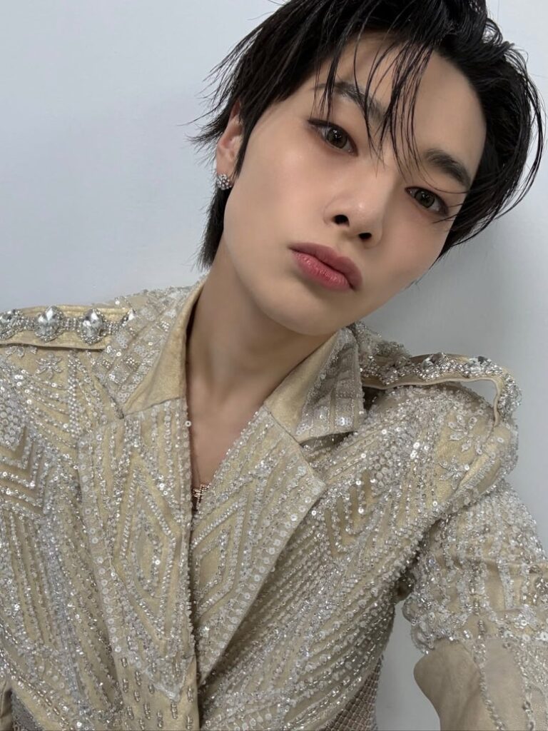Stray Kids Hyunjin wears a shimmering gold outfit for an eye-catching selfie at Korea Grand Music Awards 2025.