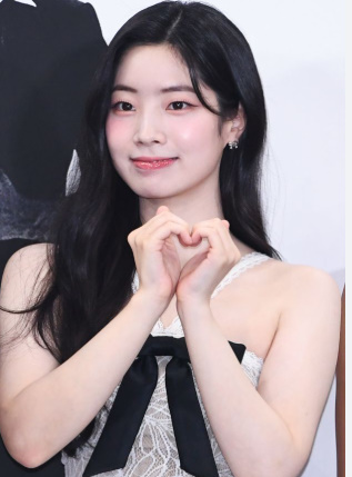 TWICE's Dahyun at the Love Me drama press conference in a lace dress, forming a heart gesture with her hands