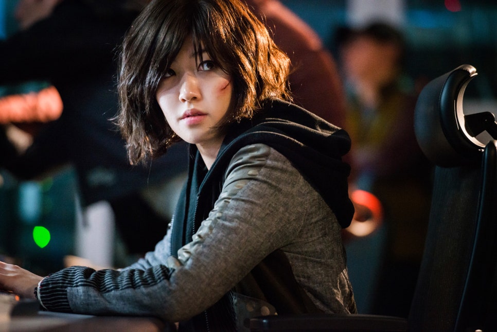 Fabricated City film female lead looking intense at computer with scratch on face