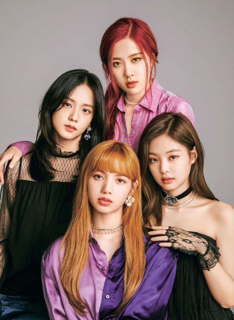 Elegant concept photo of a K-pop girl group posing closely in luxurious outfits with a soft studio background, showcasing modern beauty and fashion