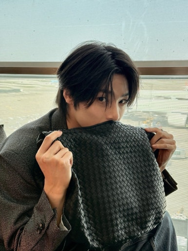 Stray Kids member teasing 'DO IT' comeback with casual airport look and textured leather bag