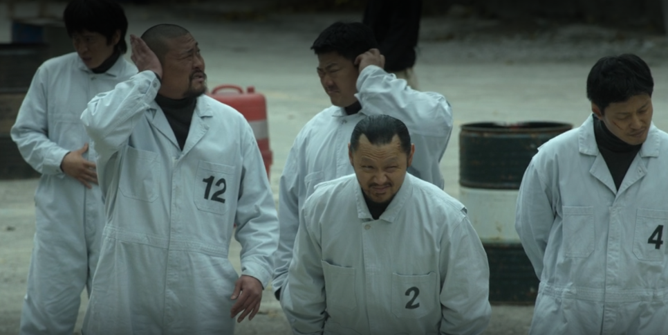 Prisoners in numbered uniforms in tense scene from “Bad Prosecutor” Korean series