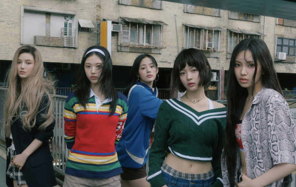 NewJeans return to ADOR – Members standing in front of a gritty urban backdrop, symbolizing resilience through legal challenges