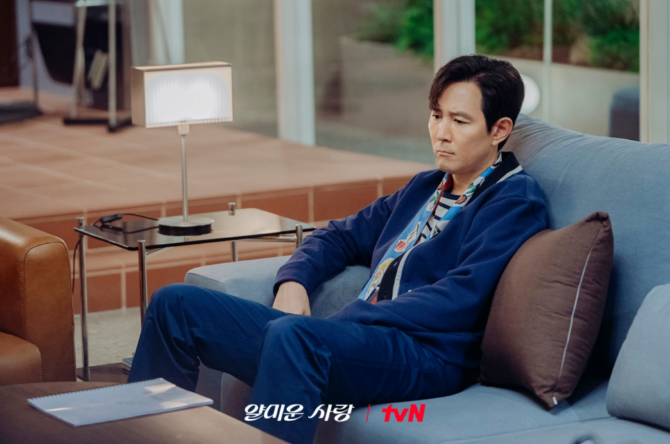 Nice to Not Meet You – Lee Jung-jae sits brooding on a couch, immersed in his character’s emotional downfall.
