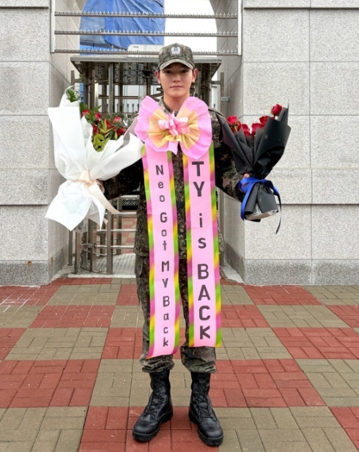Taeyong proudly holds two bouquets with TY is BACK ribbon on military discharge day